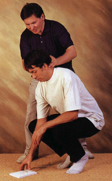 Richard Brennan, Alexander Teacher, helping pupil to bend to lift an object in a healthy way