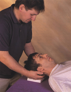 Alexander teacher gently encourages pupil's head and neck to relax